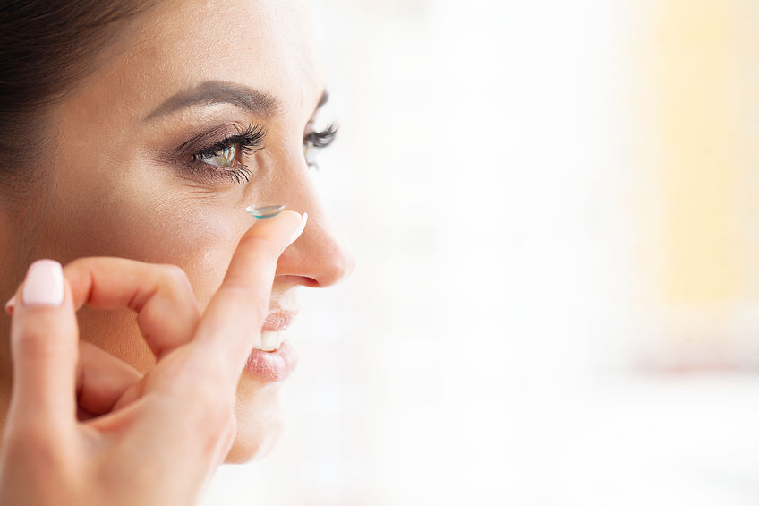 Frau setzt eine Kontaktlinse ins Auge ein, Nahaufnahme für Kontaktlinsen-Anwendung.